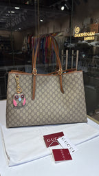 Signature monogram leather tote bag with charm